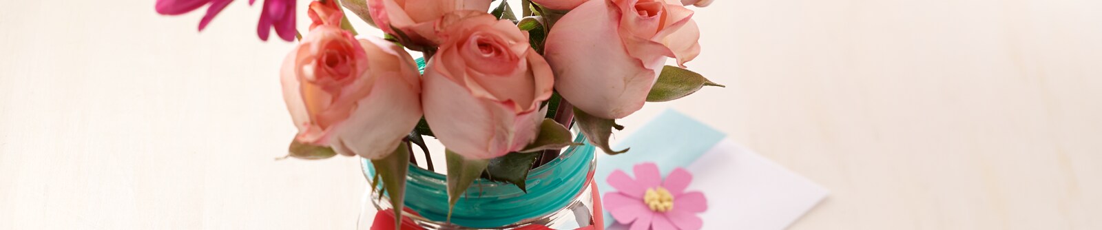 Decorated mason jar filled with pale pink roses