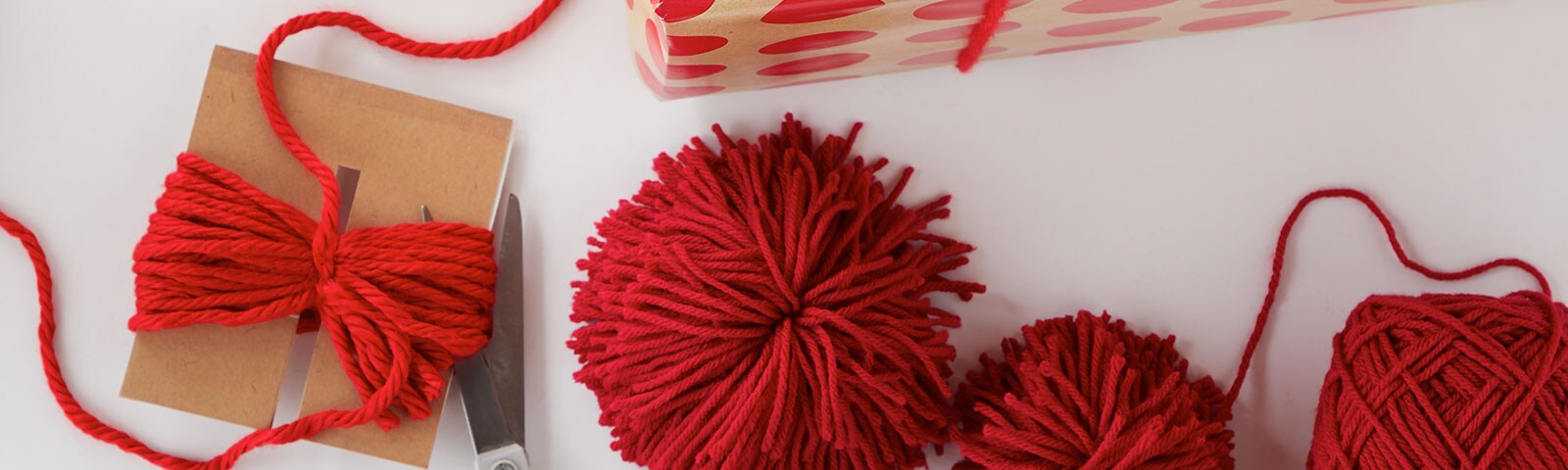 Red yarn as gift toppers on gifts Red yarn as gift toppers on gifts