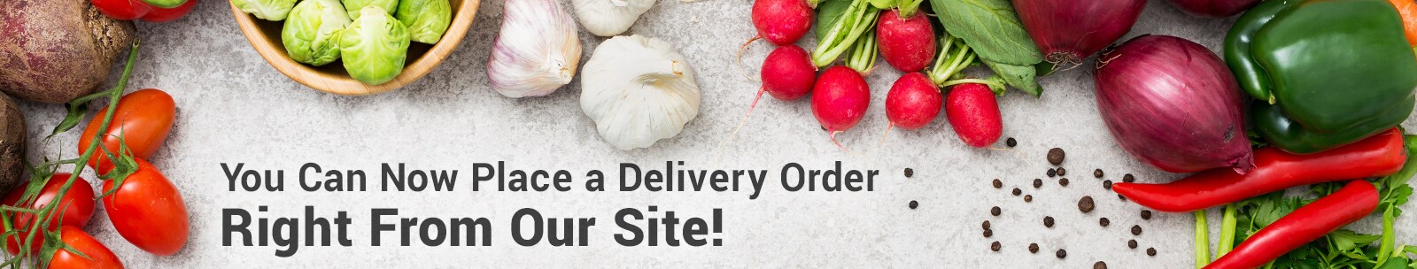 Online grocery delivery text in front of fresh produce scattered on table.
